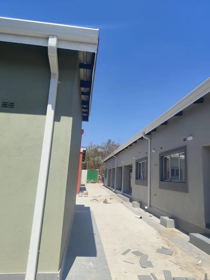 White downpipe running cleanly down a new building