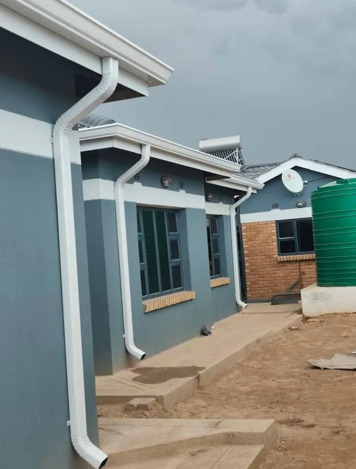 White gutters and downpipes along a row of new homes